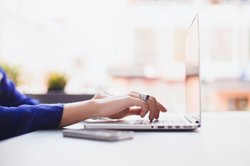 Hands typing on a laptop.