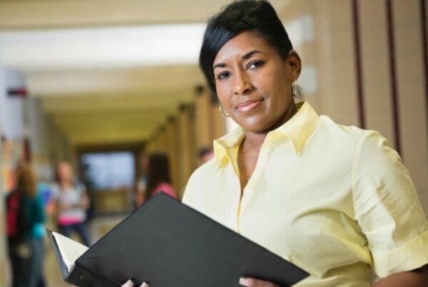 Teacher holding a lesson plan folder.