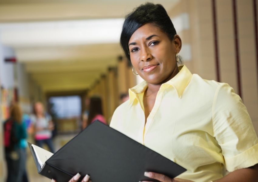 Teacher holding a lesson plan folder.