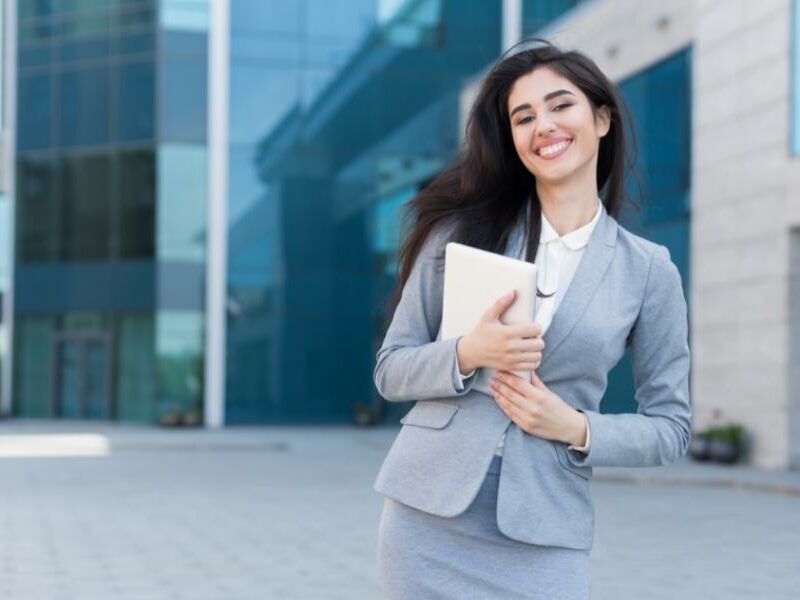 Digital marketing student standing in front of a school.