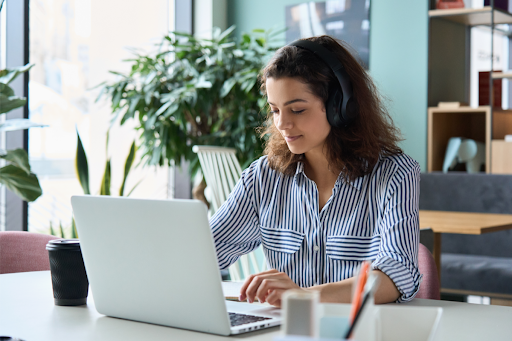 Young woman sitting at a desk using a laptop.