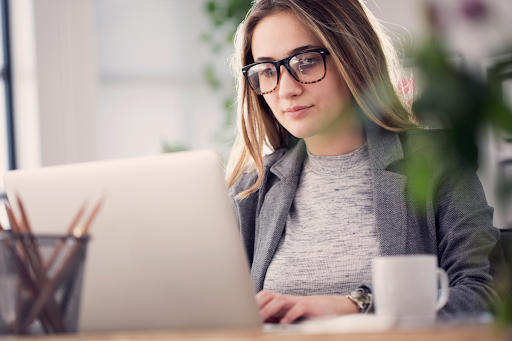 A woman working at a laptop.