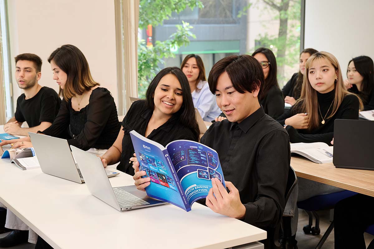 Students reading the Search Engine Optimization Marketing textbook in the classroom