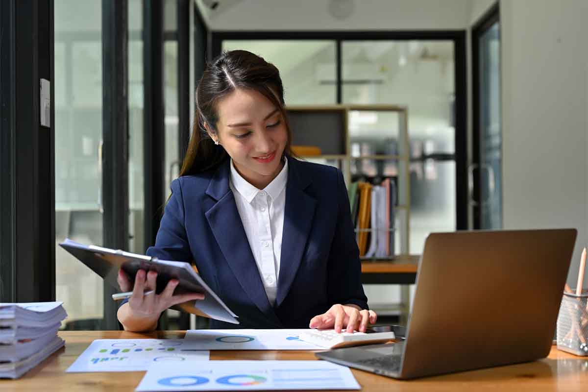 Asian businesswoman concentrating on her financial and sales rep