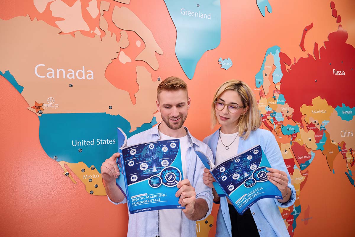 Students comparing their copies of the Digital Marketing Fundamentals textbook against the backdrop of a global map